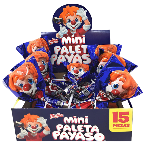 A close-up photo of a colorful, rectangular cardboard box with the brand name "Ricolino" written on it. The box contains several individually wrapped small, round candies with different colors and flavors. The candy wrapper features the image of a clown's face with a red nose, white face paint, and a colorful hat.