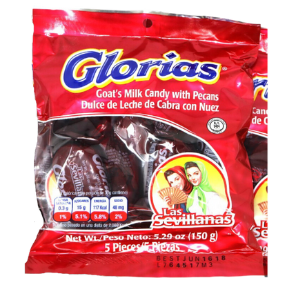 A close-up photo of a rectangular box with a red background and a yellow border. The box has a picture of a woman in traditional Spanish dress, holding a plate of candy. The candy is called "Glorias" and is made of a sticky, chewy mixture of milk and sugar, with a peanut in the center. The box is labeled "Las Sevillanas" in large, bold letters at the top